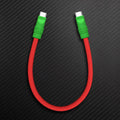 Red silicone short USB C to USB C charging cable with green ends.
