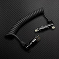 Black coiled multi-connector charging cable with metallic heads.